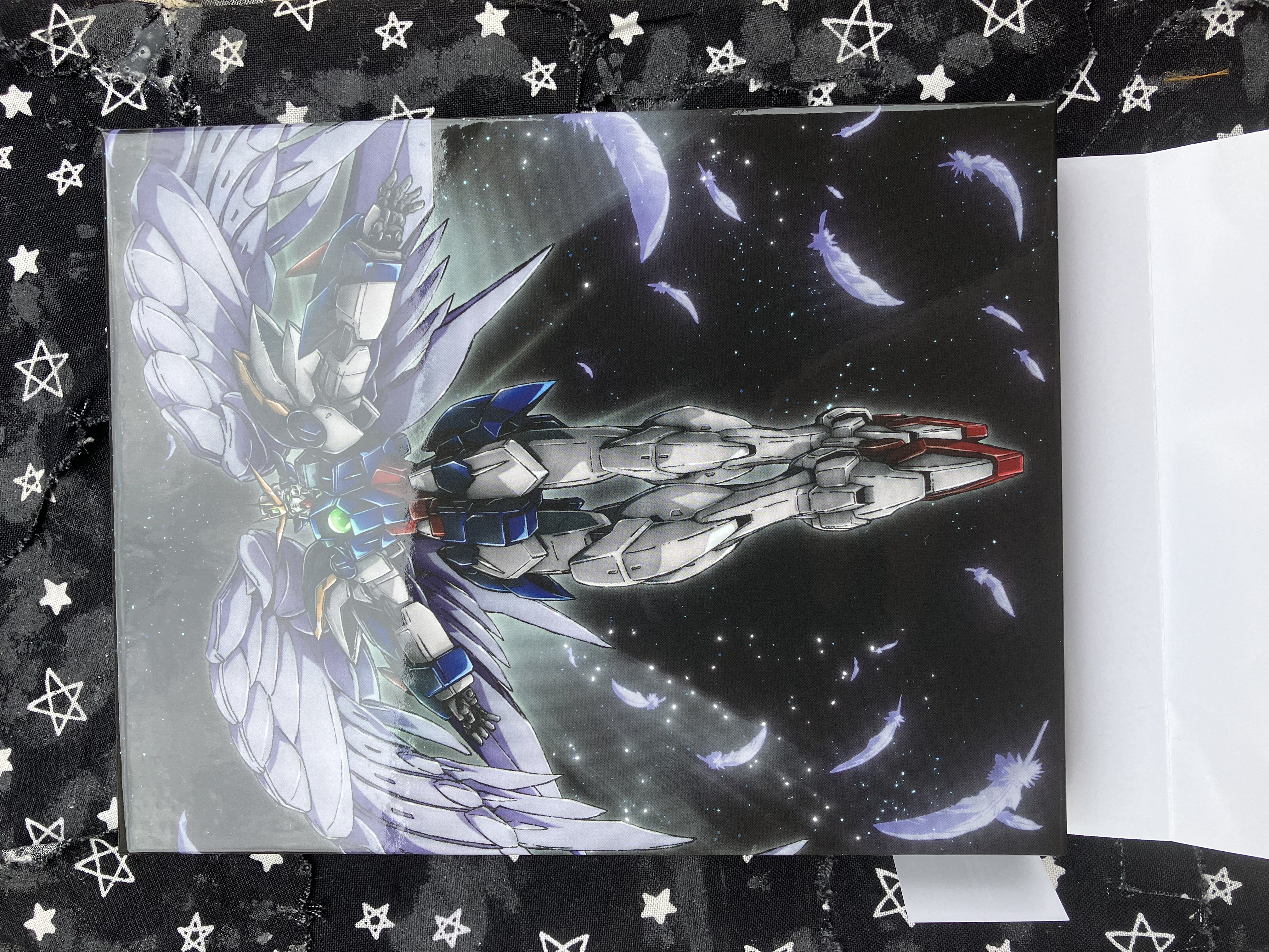 Back of Gundam wing ultra hd cover with Wing zero flying with angel wings floating around it.